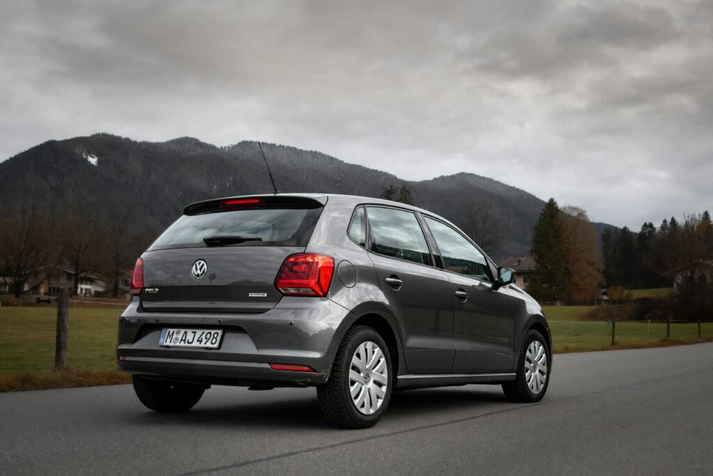 Volkswagen car parked on a scenic road in Tegernsee, Germany with mountains in the background.