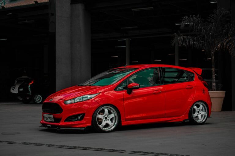 A stylish red Ford Fiesta parked in an urban setting, showcasing modern automotive design.