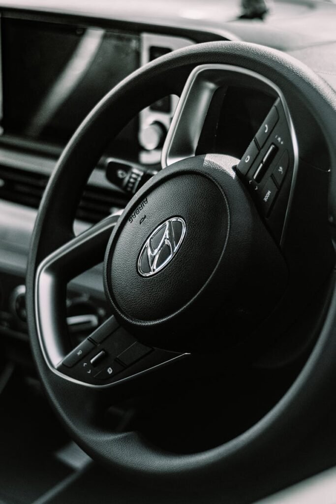 Detailed view of a vehicle's steering wheel with dashboard features, perfect for automotive themes.
