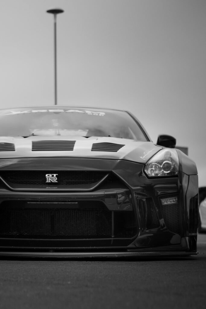 Black and white front view of a lowered sports car, highlighting design and elegance.