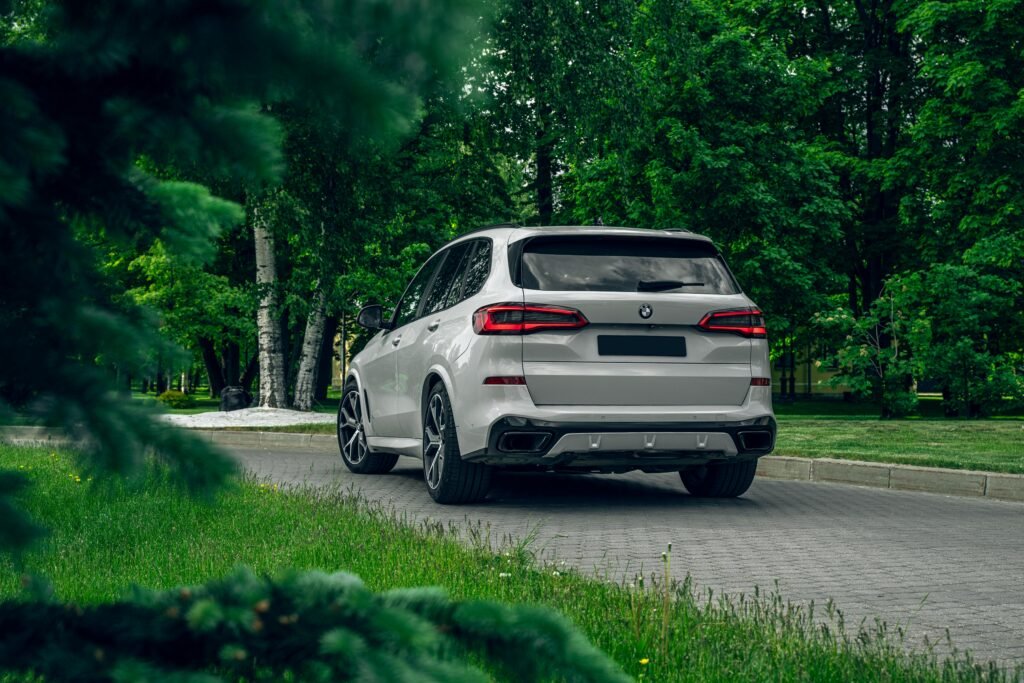 Elegant white SUV parked on a tree-lined street, showcasing luxury and nature.