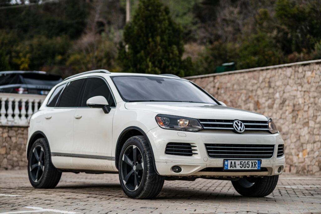 A sleek white Volkswagen Touareg SUV parked outdoors on a paved lot, showcasing modern design.