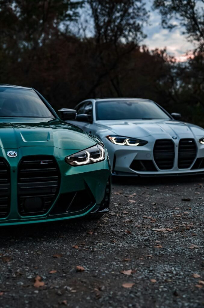 Two BMW sports cars parked outdoors at dusk, showcasing luxury and power.